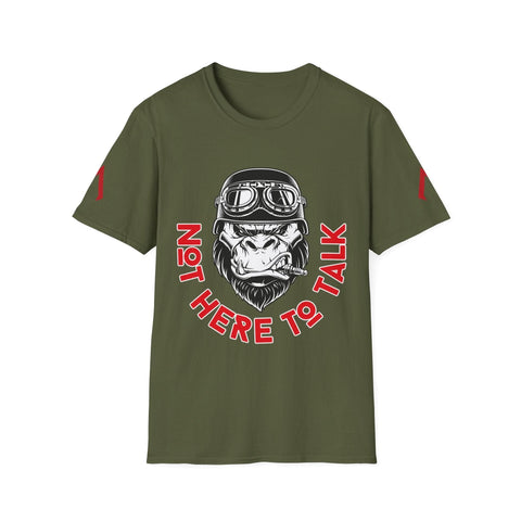 The image shows an olive green t-shirt featuring a bold, graphic design. At the center, there is an illustration of a gorilla's head wearing aviator goggles and a helmet, with a cigar clenched in its teeth. Surrounding the gorilla, in a semi-circle, are the words "NOT HERE TO TALK" in red, bold letters with a white outline. The design conveys a tough, no-nonsense attitude.